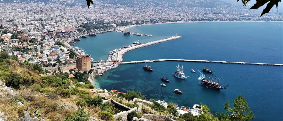 Hafen und Bucht von Alanya vom Burgberg aus, dahinter die Stadt und die Berge