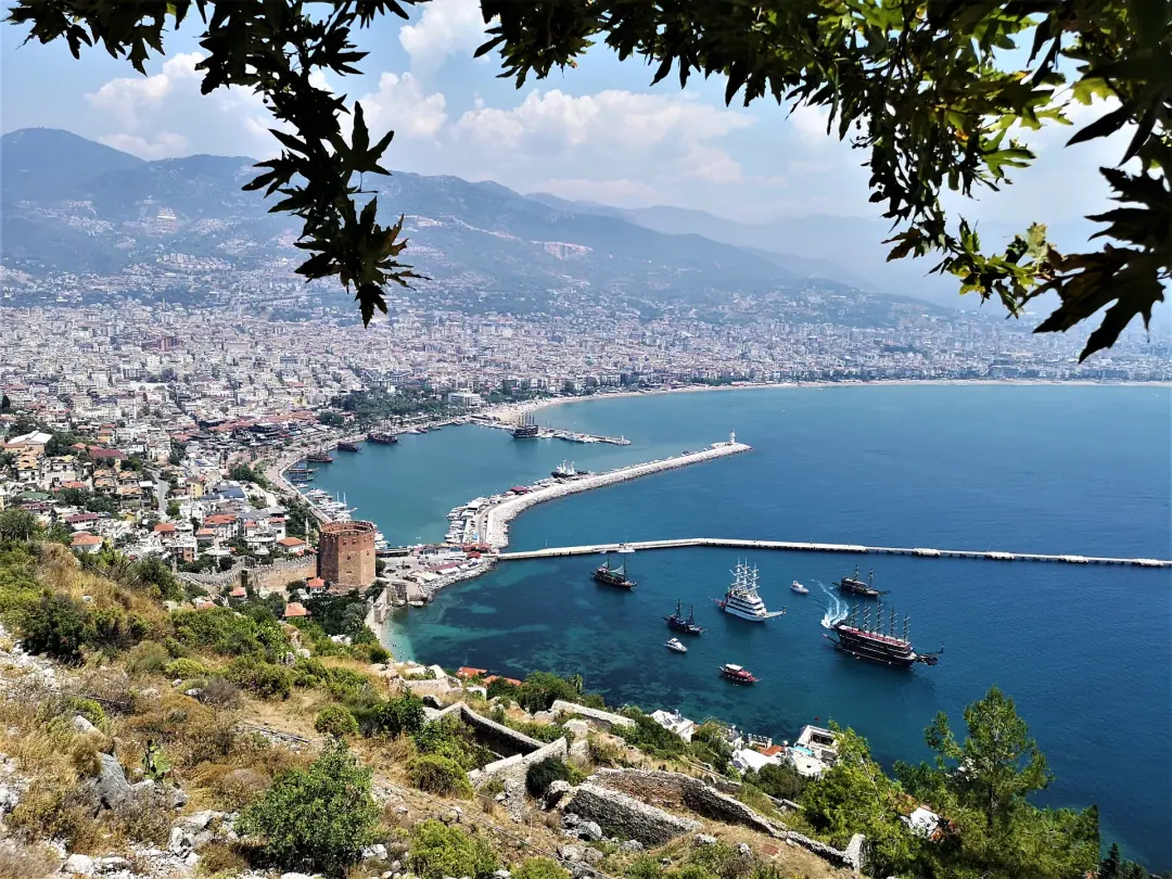 Hafen und Bucht von Alanya vom Burgberg aus, dahinter die Stadt und die Berge