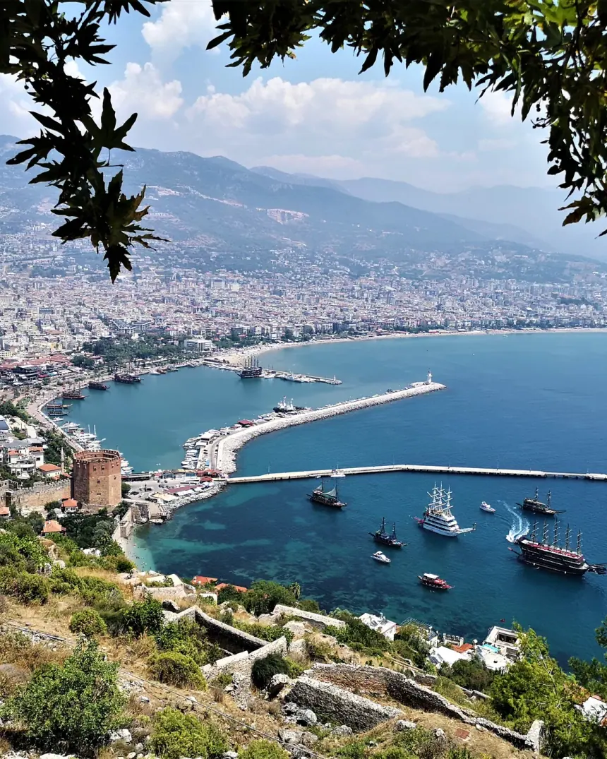 Hafen und Bucht von Alanya vom Burgberg aus, dahinter die Stadt und die Berge