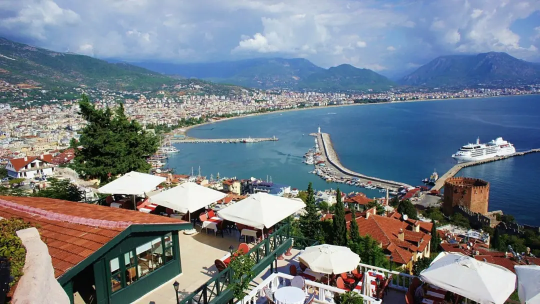Bucht und Hafen von Alanya unterhalb einer Hangterrasse, im Hintergrund das Taurusgebirge