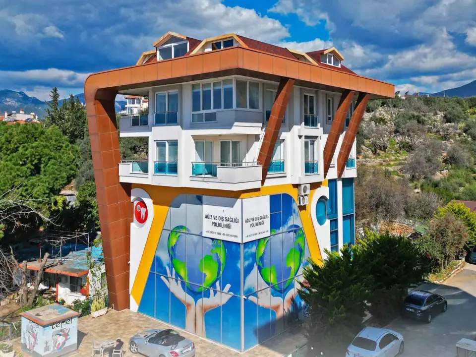 Das Gebäude von Dental Art Alanya zwischen Bäumen
