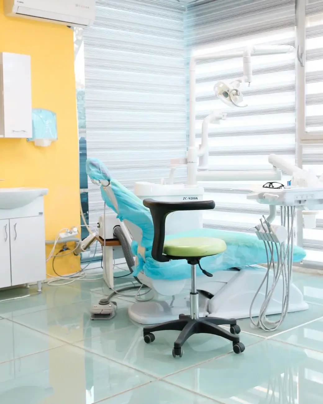 Ein Behandlungsraum bei Dental Art Alanya mit Stuhl, Schränken und Jalousien