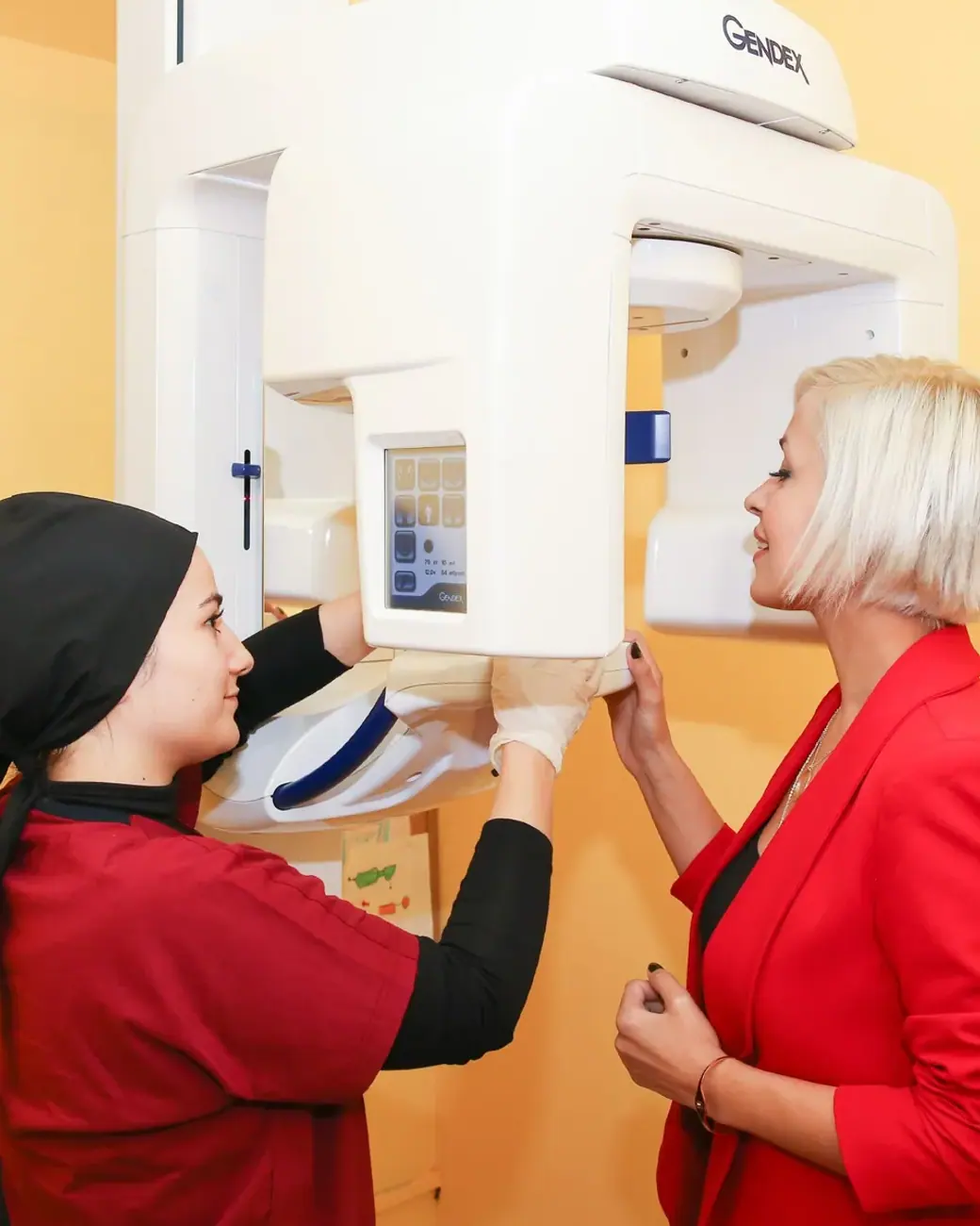 Ein Mitglied des Dental-Art-Teams positioniert eine Patientin am Röntgengerät