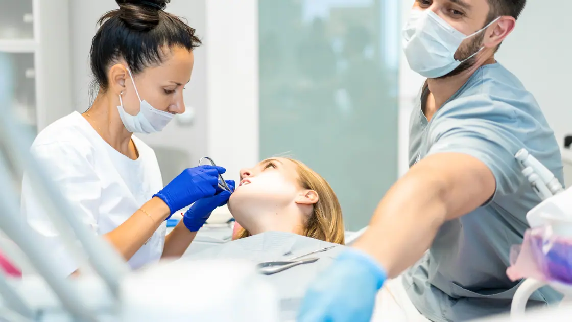 Zwei Fachkräfte arbeiten an einer Patientin, eine hält den Sauger