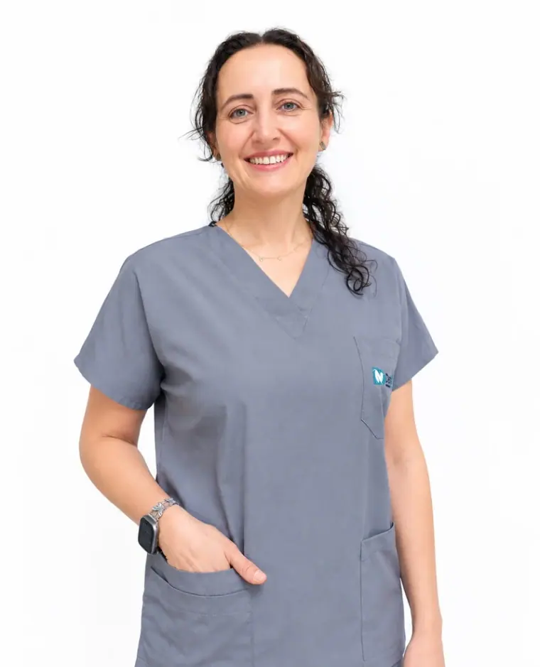 Esra Namlı, Zahnärztin bei Dental Art Alanya, lächelnd in der grauen Praxiskleidung der Klinik